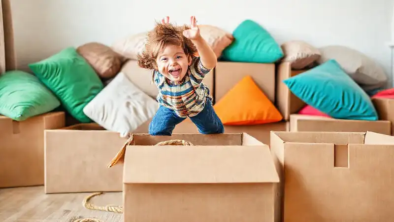 Niño juega alegremente con cajas