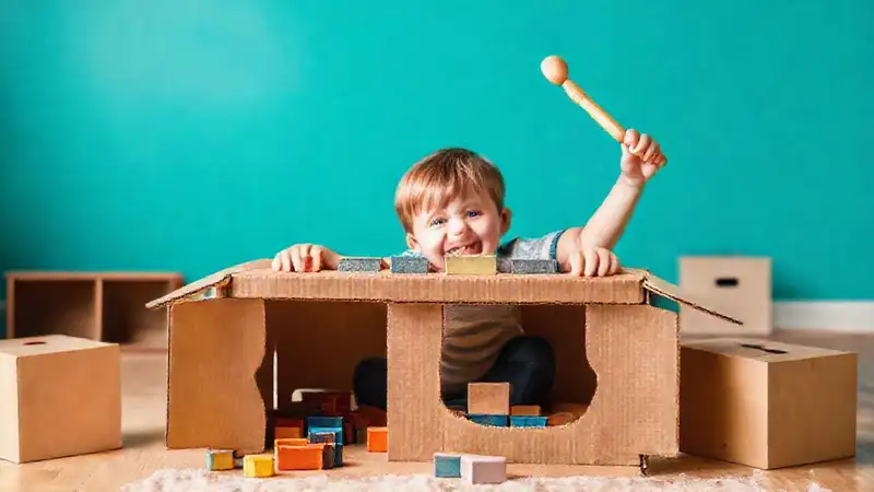 Un niño juega feliz con materiales simples